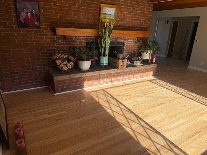 Hardwood flooring installation by brick fireplace in Northern Colorado home